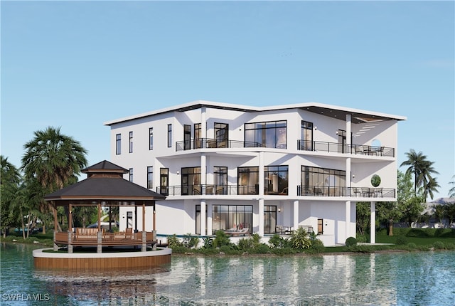 back of property featuring a gazebo, a water view, and stucco siding