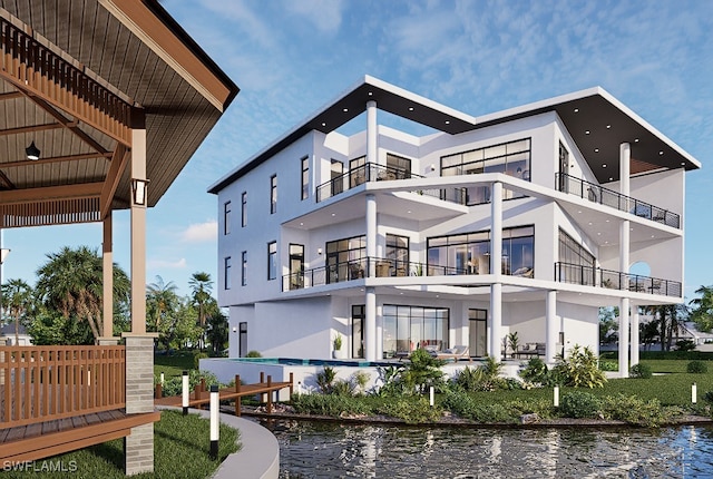 rear view of house with stucco siding and a water view