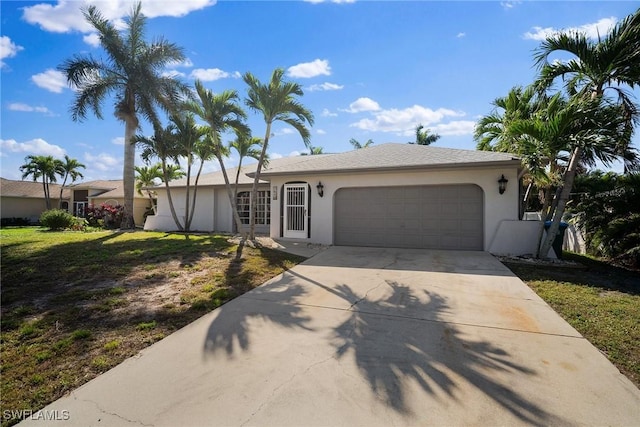 ranch-style home featuring a garage, a front yard, driveway, and stucco siding