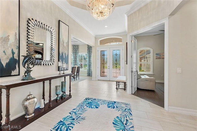 entryway with an inviting chandelier, baseboards, ornamental molding, and french doors