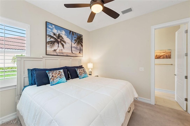 bedroom featuring visible vents, ceiling fan, light carpet, and baseboards