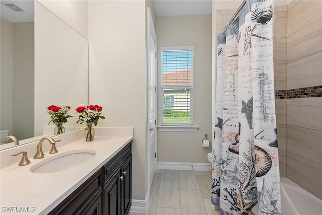 full bath with visible vents, vanity, toilet, and baseboards