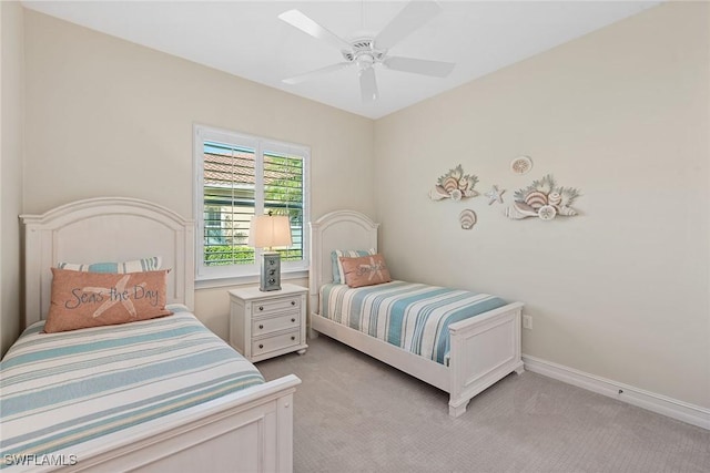 bedroom featuring light carpet, ceiling fan, and baseboards