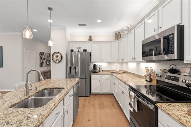 kitchen with visible vents, light wood-style flooring, appliances with stainless steel finishes, ornamental molding, and a sink