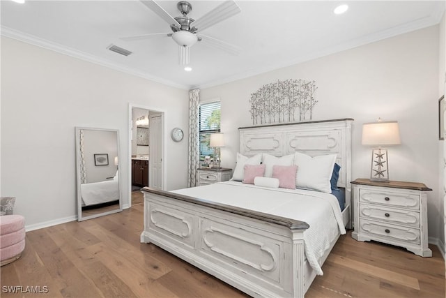 bedroom with ornamental molding, visible vents, baseboards, and wood finished floors