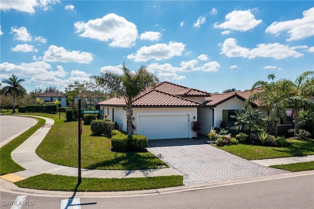 view of front of home with decorative driveway, a tile roof, stucco siding, a front yard, and a garage