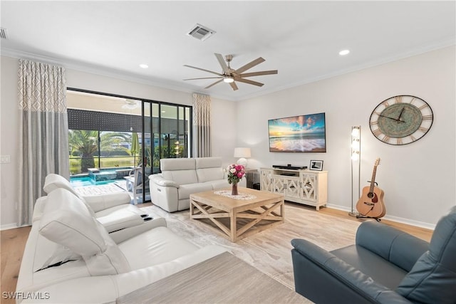 living area with light wood-style floors, baseboards, visible vents, and crown molding