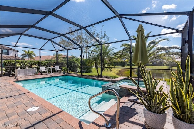 view of swimming pool featuring a pool with connected hot tub, a patio area, and a lanai