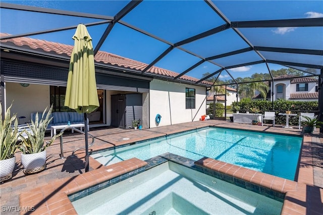 view of swimming pool with glass enclosure, a patio area, and a pool with connected hot tub