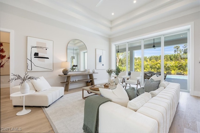 living area featuring light wood-style floors, recessed lighting, baseboards, and a high ceiling