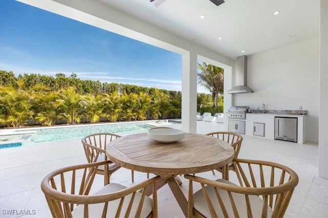 view of patio / terrace featuring a sink, a grill, exterior kitchen, an outdoor pool, and outdoor dining space