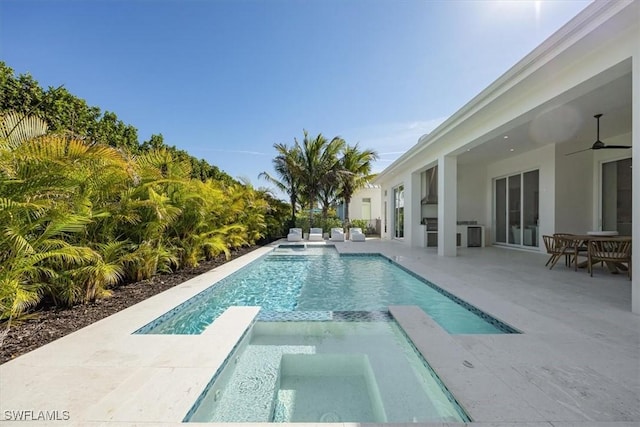 view of swimming pool featuring a pool with connected hot tub, a patio area, and a ceiling fan