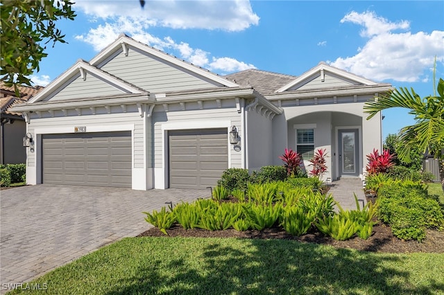 view of front facade featuring an attached garage and decorative driveway