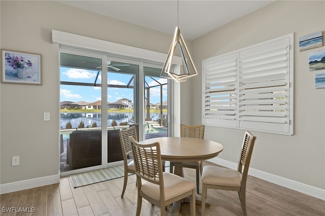 dining space featuring baseboards, a sunroom, and light wood-style floors