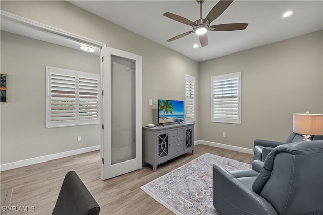 living area with light wood-type flooring, ceiling fan, baseboards, and recessed lighting