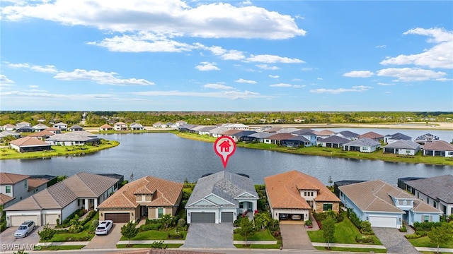 drone / aerial view with a water view and a residential view