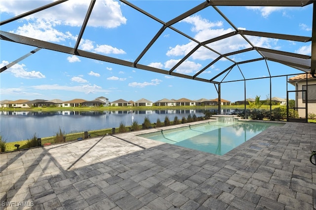 pool featuring glass enclosure, a patio area, a residential view, and a water view