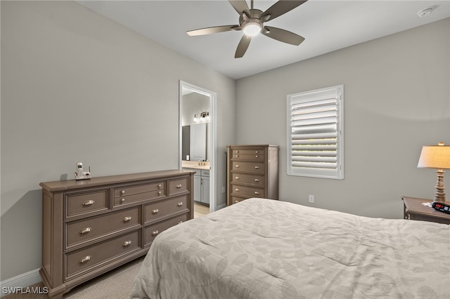 bedroom with light carpet, connected bathroom, and ceiling fan