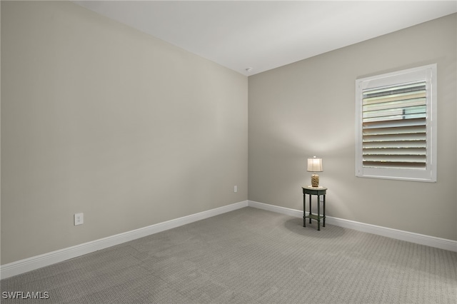 carpeted empty room with baseboards