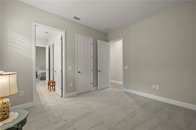 unfurnished bedroom with light carpet, baseboards, and visible vents