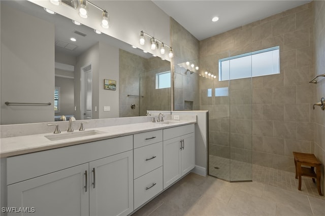 full bathroom featuring tile patterned floors, walk in shower, a sink, and double vanity