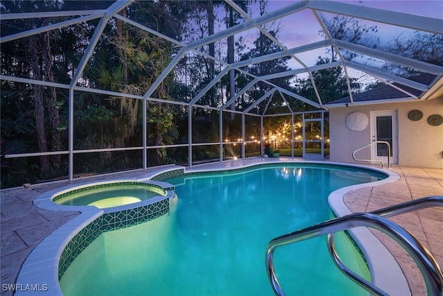 view of swimming pool with glass enclosure, a pool with connected hot tub, and a patio area