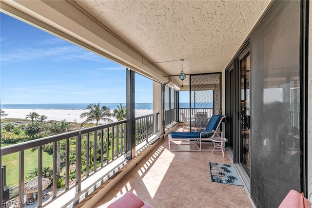 balcony with a water view and a beach view