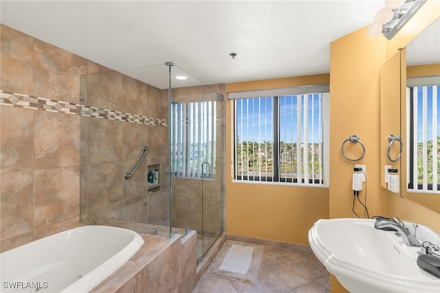 bathroom featuring a stall shower, baseboards, tile patterned floors, a sink, and a bath