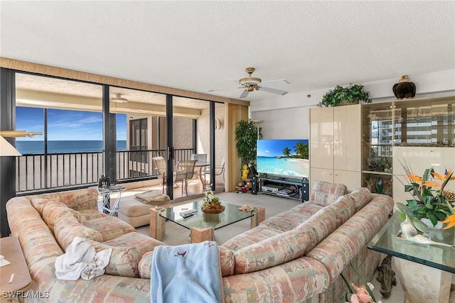 living area featuring a ceiling fan and a textured ceiling