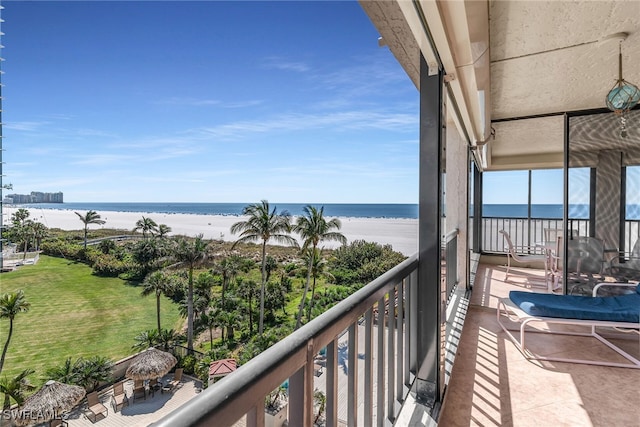 balcony featuring a water view and a beach view