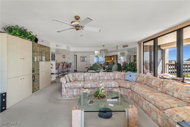 living room with ceiling fan, concrete floors, visible vents, and a textured ceiling