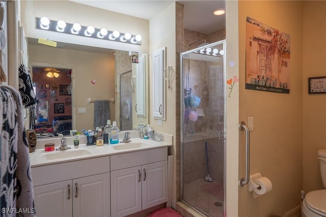 ensuite bathroom with toilet, a shower stall, a sink, and ensuite bathroom