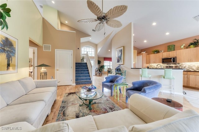 living area featuring visible vents, a ceiling fan, stairway, light wood-type flooring, and recessed lighting