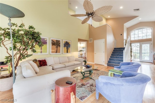 living room with stairway, visible vents, and wood finished floors