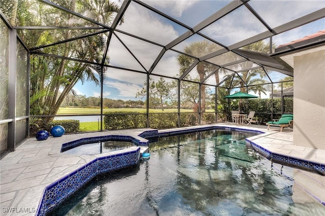 view of pool with a patio, glass enclosure, a water view, and a pool with connected hot tub