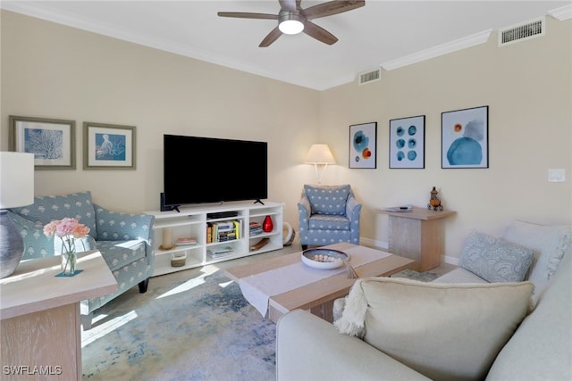 living area with ceiling fan, visible vents, and ornamental molding