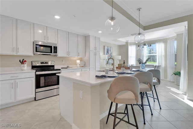 kitchen featuring appliances with stainless steel finishes, light tile patterned flooring, a sink, and ornamental molding