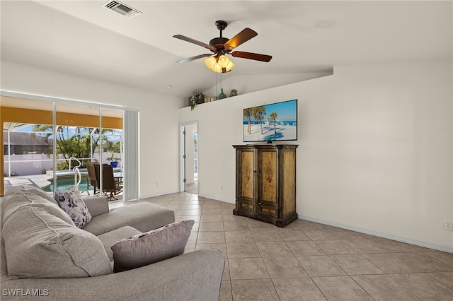 living room featuring visible vents, baseboards, light tile patterned floors, lofted ceiling, and ceiling fan