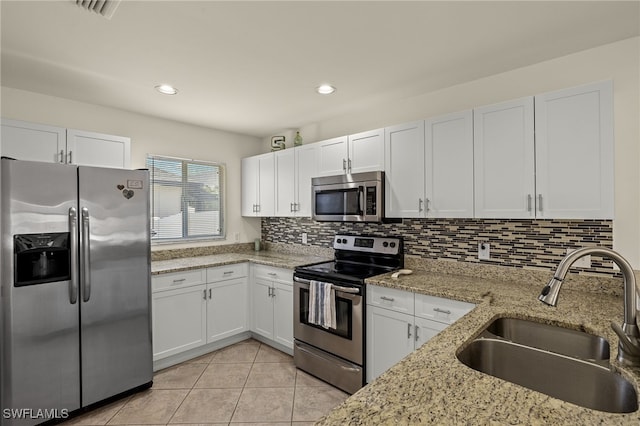 kitchen featuring a sink, white cabinetry, appliances with stainless steel finishes, and light tile patterned floors