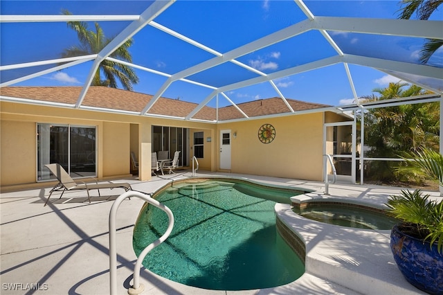 view of swimming pool featuring a patio area, a lanai, and a pool with connected hot tub