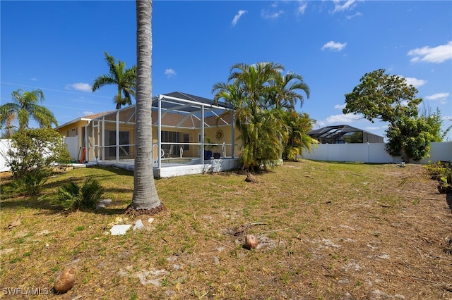 view of yard with a lanai and fence