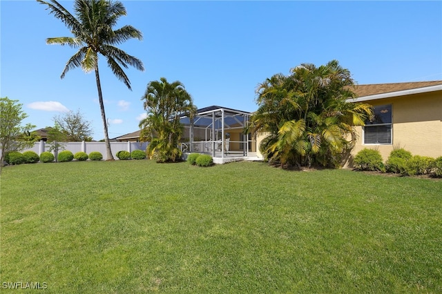 view of yard featuring a lanai and fence