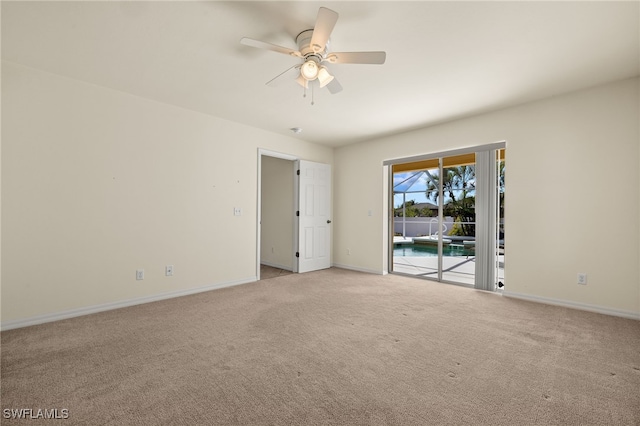 empty room featuring a ceiling fan, baseboards, and light carpet