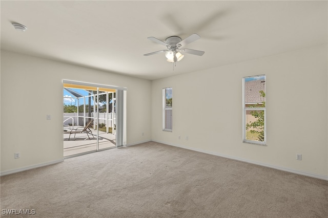 unfurnished room featuring carpet flooring, a ceiling fan, baseboards, and a healthy amount of sunlight