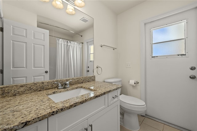 bathroom with a wealth of natural light, visible vents, toilet, and tile patterned flooring