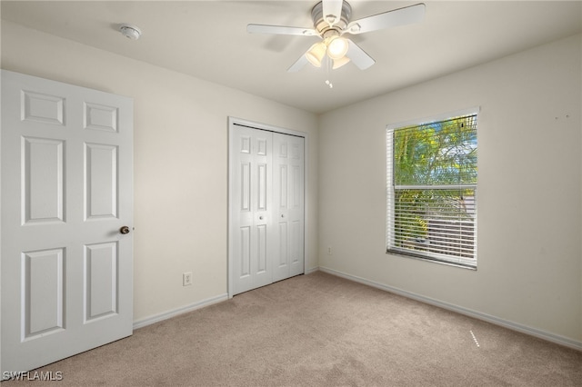 unfurnished bedroom with a closet, ceiling fan, baseboards, and carpet