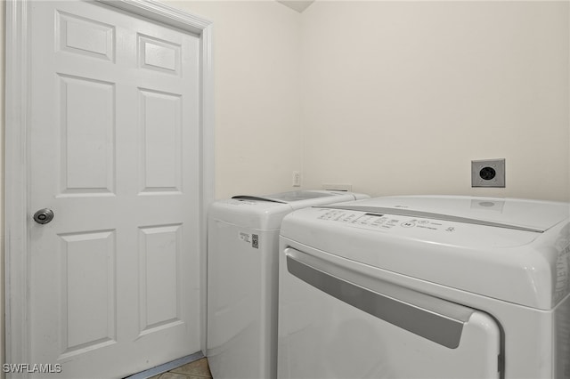 laundry area with light tile patterned floors, laundry area, and washer and clothes dryer