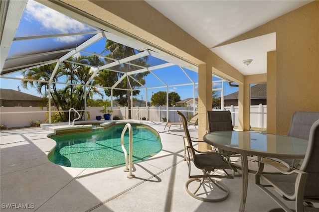 view of pool with a pool with connected hot tub, a lanai, a fenced backyard, outdoor dining space, and a patio