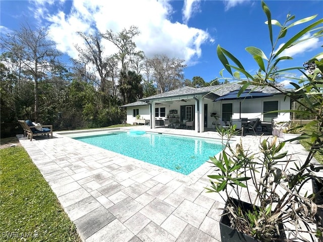 pool with a patio area and a ceiling fan