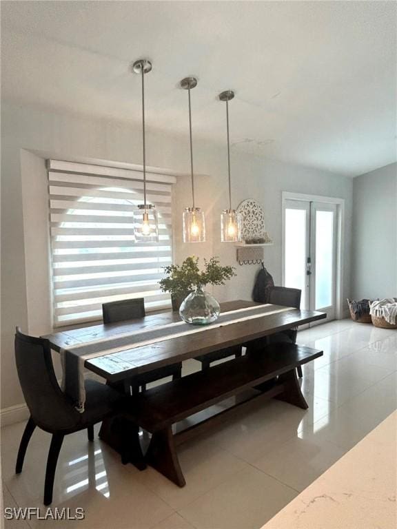 dining space with light tile patterned floors and french doors